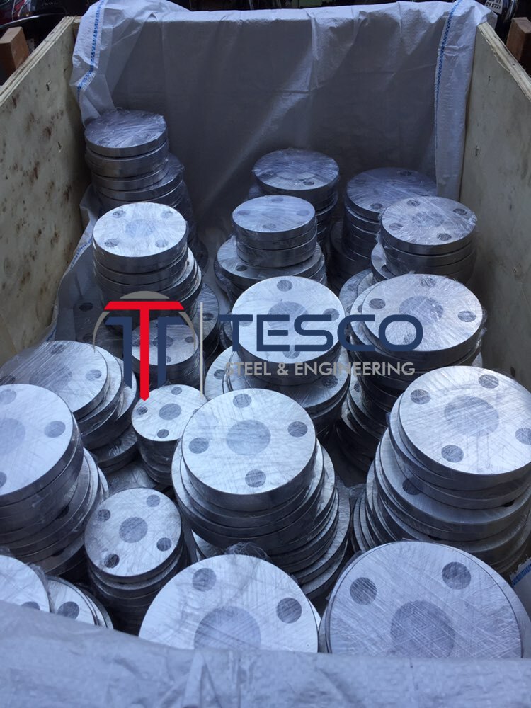 904L blind flanges UNS N08904 / F904L high-alloy austenitic stainless steel stacked in export crate — Tesco Steel & Engineering