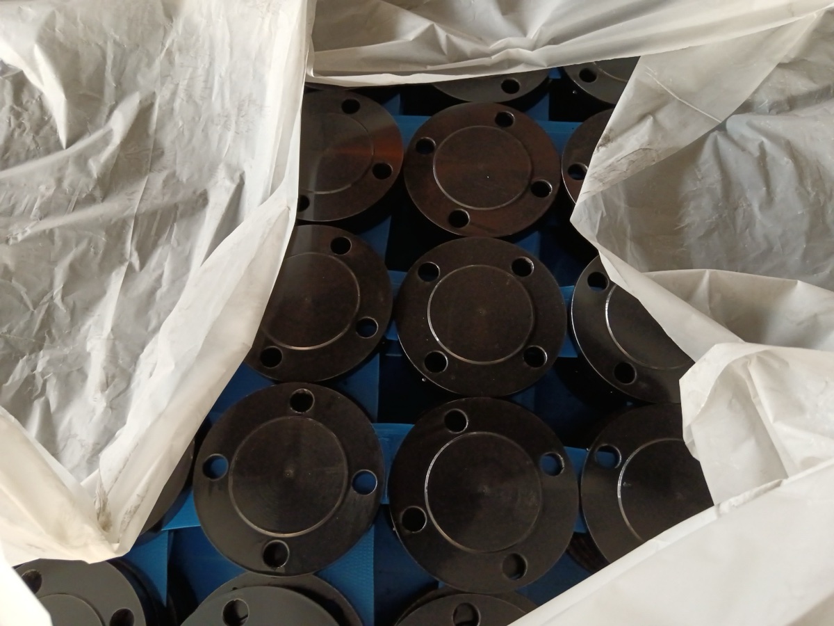 Black coated ASTM A105 raised face blind flanges packed in lined export crate at the works