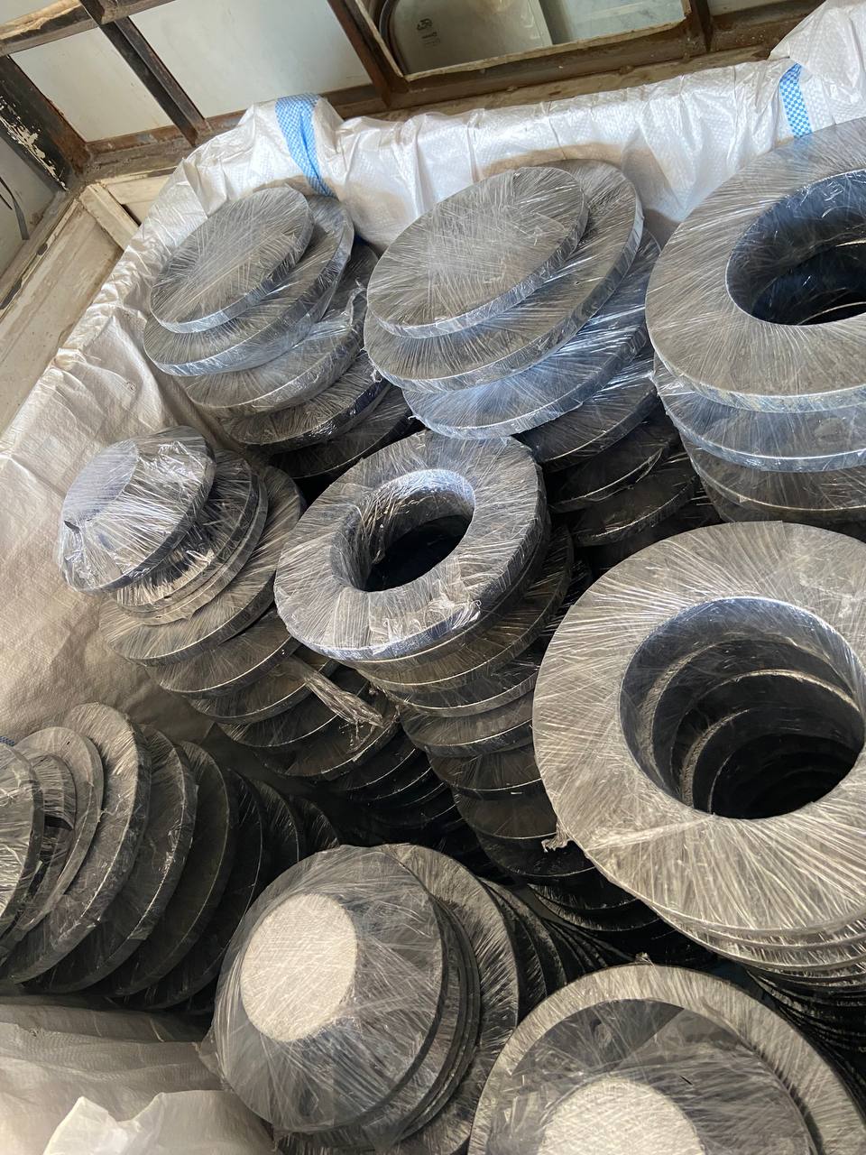 ASTM A105 carbon steel weld neck flanges individually plastic-wrapped and bulk-loaded for export — carbon steel WNRF flanges manufacturer exporter Tesco Steel India