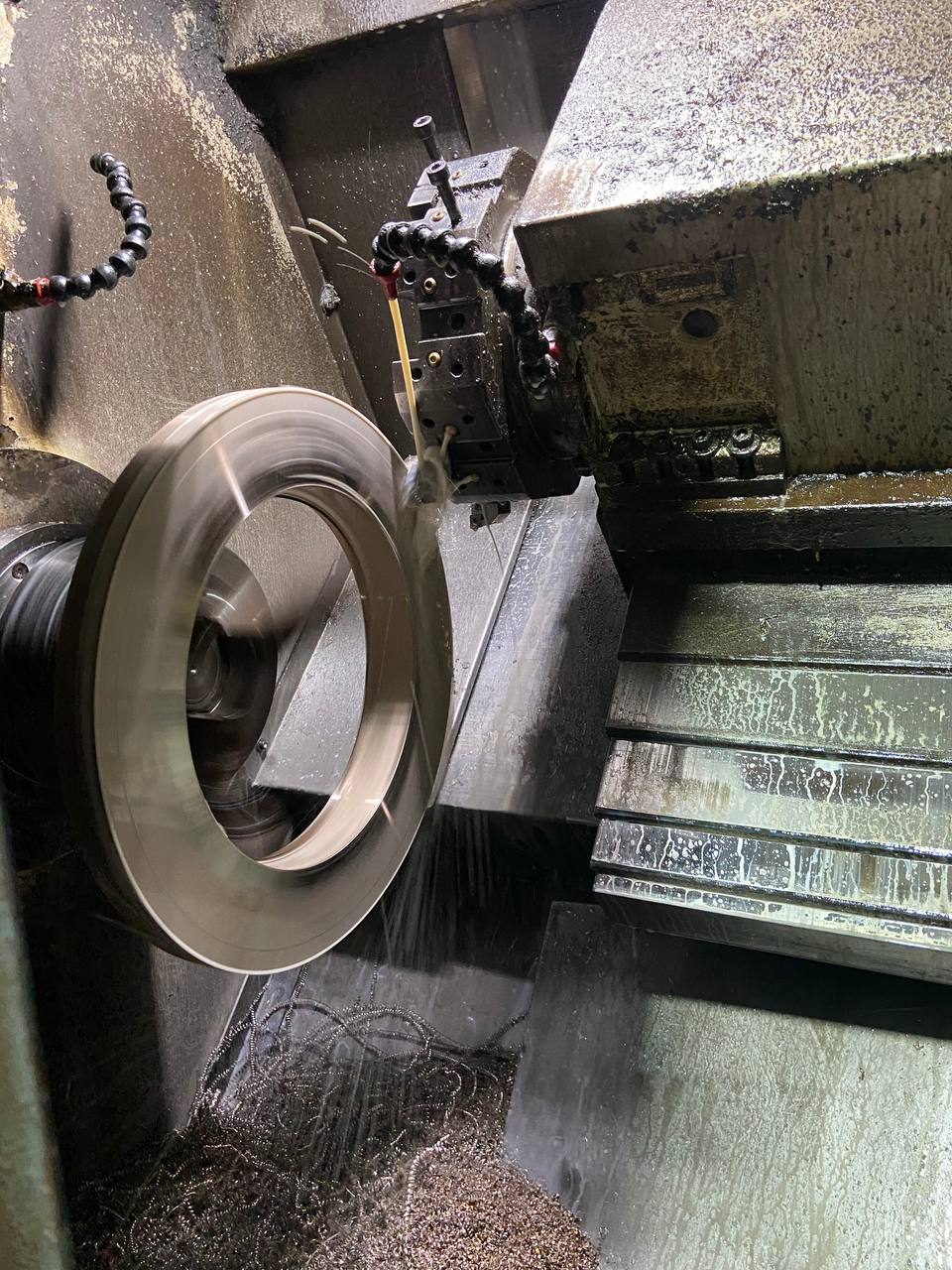 Copper Nickel 90/10 flange being turned on CNC lathe with metal chips during precision manufacturing