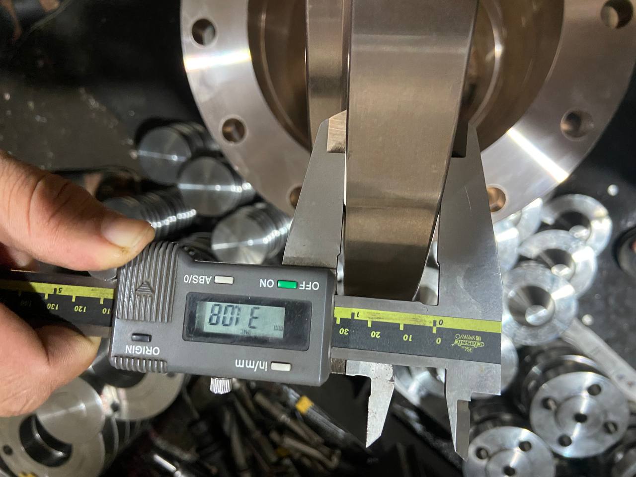 Dimensional inspection of Copper Nickel flange face width using digital vernier caliper during in-process quality control