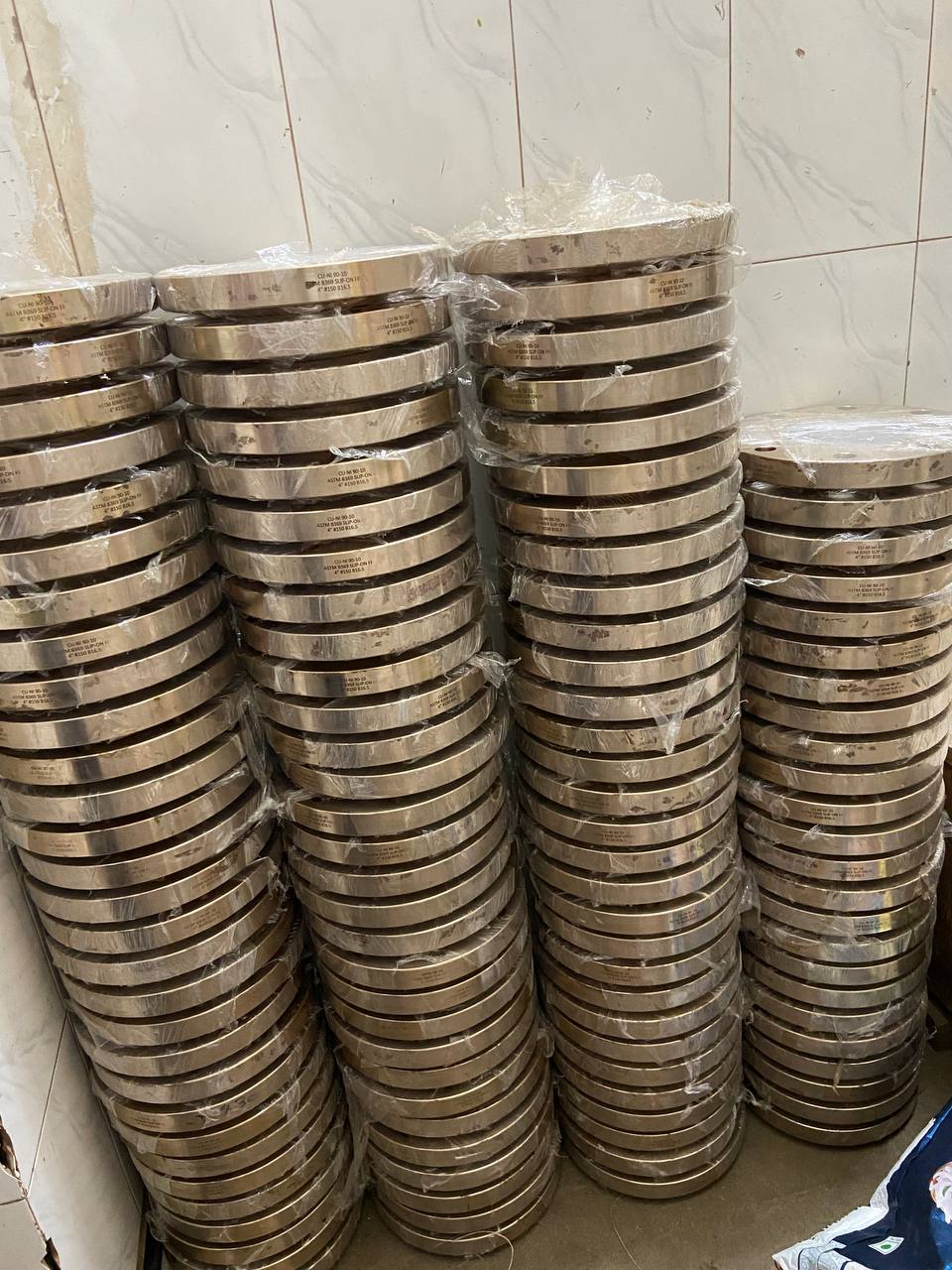 Copper Nickel 90/10 flanges individually wrapped in moisture-barrier plastic film stacked in bulk ready for export dispatch