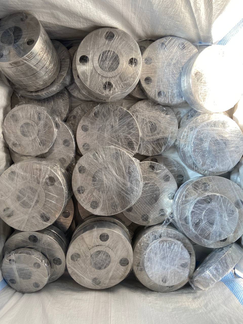 Small diameter duplex steel flanges individually plastic-wrapped and bulk-packed in export container — ASTM A182 F51 F60, Tesco Steel & Engineering Mumbai India