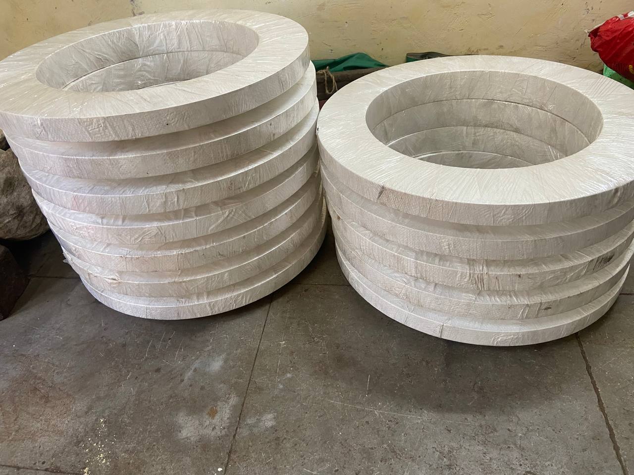 Two large stacks of duplex steel large-diameter flanges paper-wrapped ready for international export — ASTM A182 F51 F53 F60, Tesco Steel & Engineering Mumbai