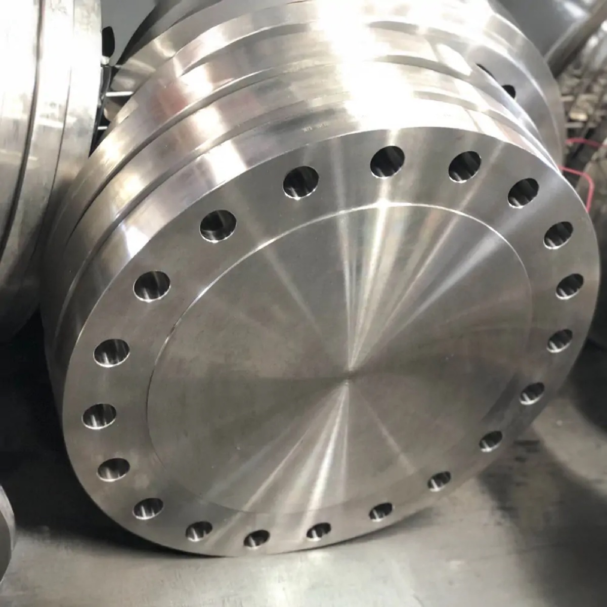 Large machined stainless steel blind flange with bright spiral finish in production