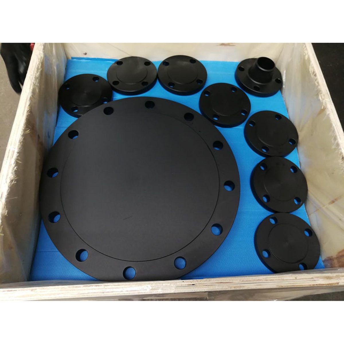 Black coated A105 raised face blind flanges packed with weld neck flanges in lined export crate