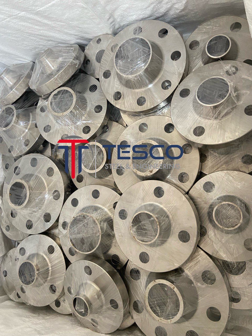 ASTM A182 stainless steel weld neck flanges individually plastic-wrapped and bulk-packed for export — Tesco Steel & Engineering India