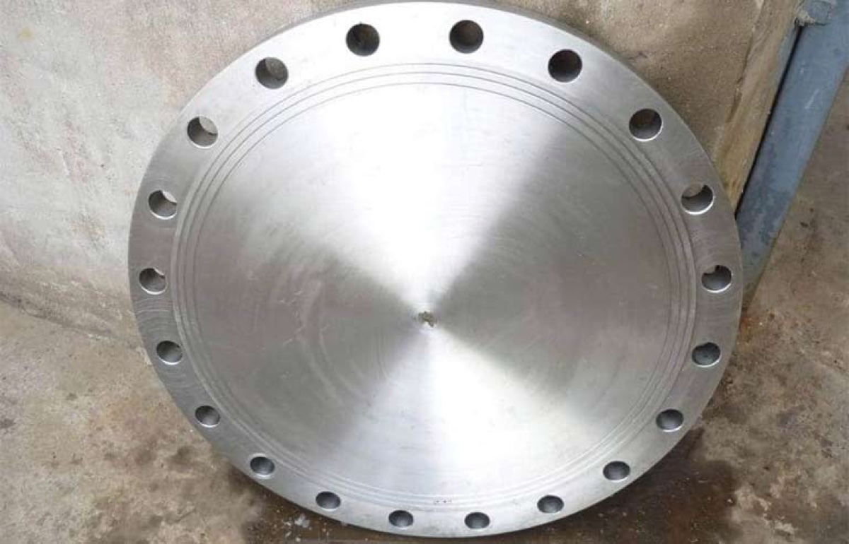 Large machined stainless steel blind flange with concentric finish standing at the works