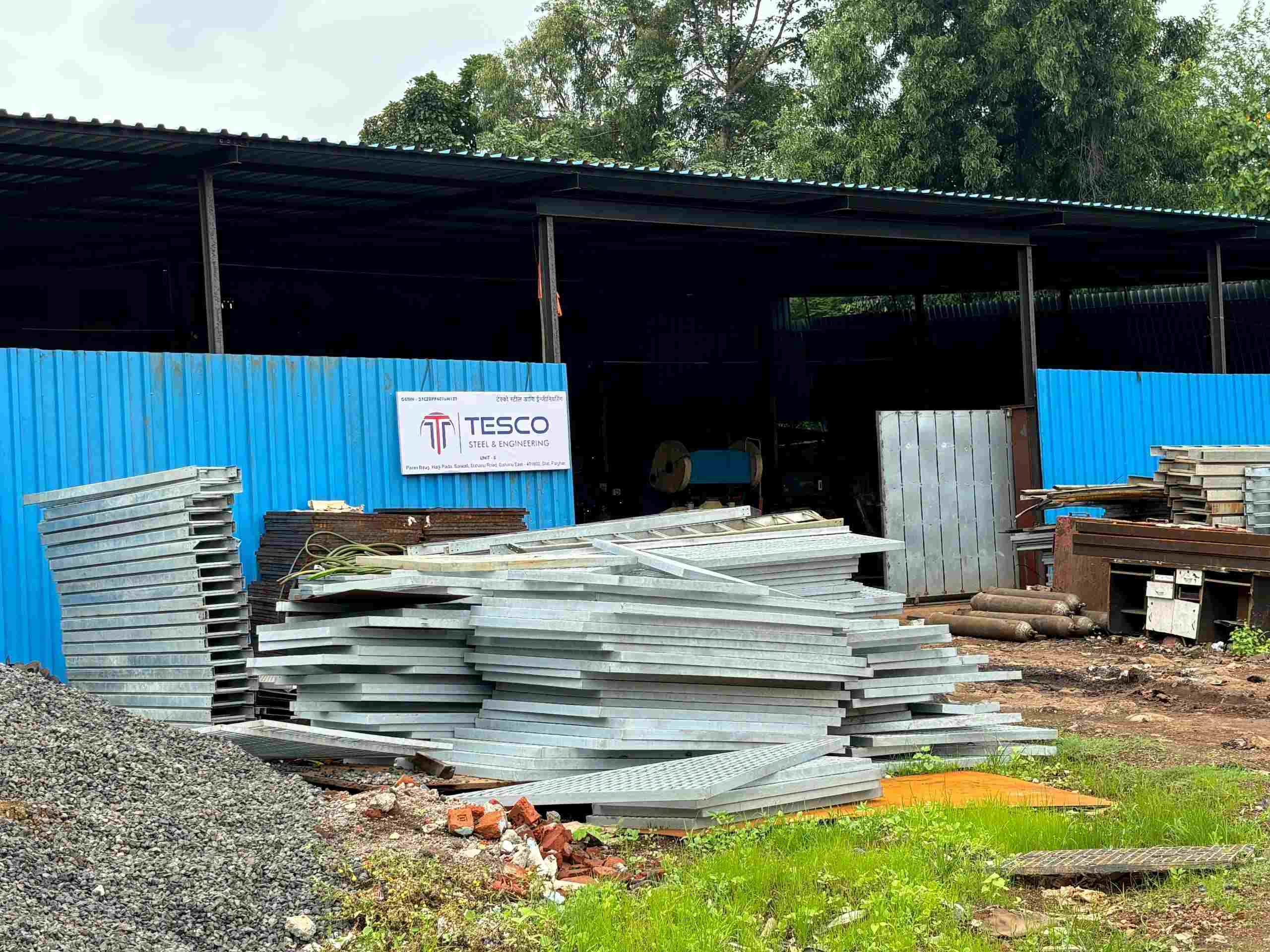 Steel grating manufacturer — Tesco Steel & Engineering factory with stacks of galvanized steel grating panels